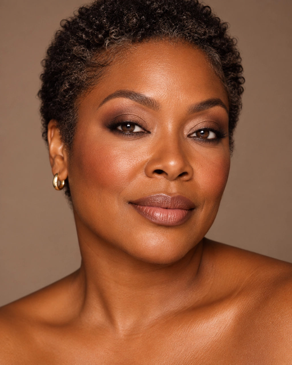 Close-up editorial portrait of a Black woman in her 40s wearing softly blended toasted neutral eye makeup
